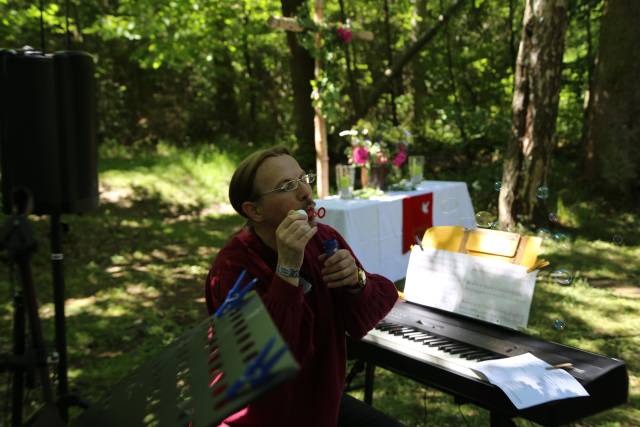 Ökumenischer Pfingstgottesdienst an der Köhlerhütte unter schattigen Bäumen